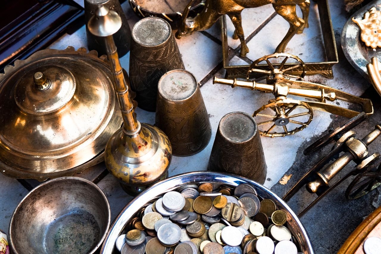 collection-03 A collection of vintage brass items and coins arranged in a still life composition, showcasing historical artifacts.