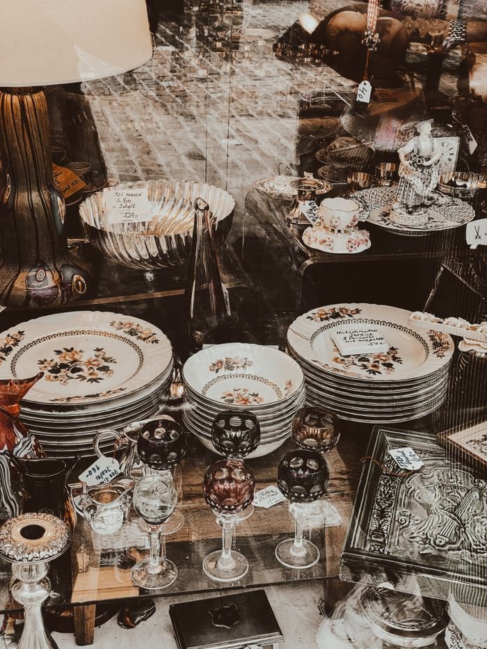 delivery-policy A vintage collection of porcelain dishes and glassware on display with an antique feel.