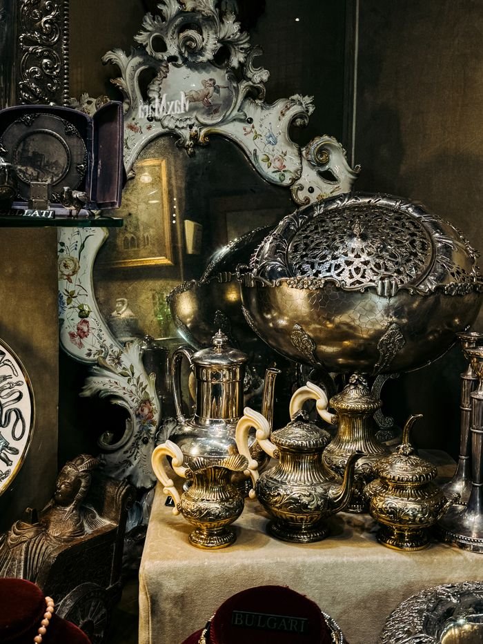 summer-sale Ornate antique silverware collection on display in a vintage Roman shop.